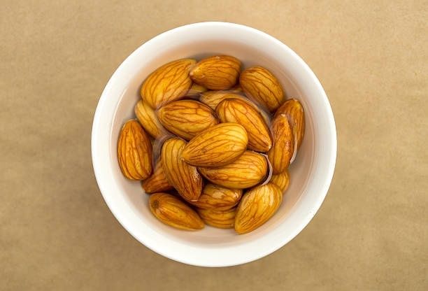 Skål med mandlar som blötläggs i vatten inför råa rätter